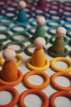 small wooden toy figures sitting on top of rings