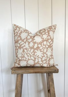 a brown and white pillow sitting on top of a wooden stool