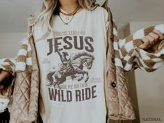 Gear up for your journey with our 'Jesus Guide Me On This Wild Ride' Western Christian T-Shirt. Crafted with comfort in mind, this Coastal Cowgirl Crewneck features a bold graphic print on the front, expressing your faith with style. Whether you're hitting the trails or just embracing the wild ride of life, let this shirt be a testament to your Christian values and your adventurous spirit. Available now to accompany you on every step of your journey. * K E E P * S H O P P I N G *   ✺ Shop our entire Quite Nice Studios collection here: https://www.etsy.com/shop/QuiteNiceStudio * Q U I C K * F A C T S * ✺ 100% preshrunk cotton ✺ Wash (inside out) and dry normally (on cool for best results) * S I Z I N G * ✺ Sizing is unisex so runs like men's, though not overly large ✺ Most women Xfind their Western T Shirts For Women Simple, Cute Oversized Western Shirts, Winter Shirts Vinyl Western, Western Cricut Tshirts, Jesus And Country Music Shirt, Cricut Wrangler Shirt, Western Shirts Vinyl Bohemian, Womens Faith Shirts, Cute Vinyl Shirts Women Christian