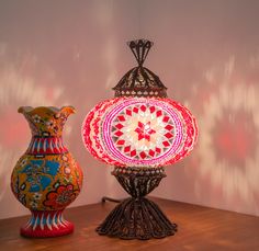 two colorful vases sitting on top of a wooden table