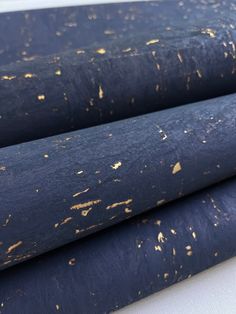 three rolls of blue fabric with gold speckles on them, sitting next to each other