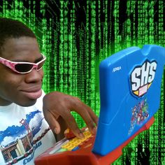 a young man wearing sunglasses playing with a toy computer in front of a green background