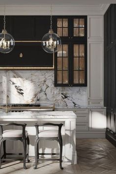 an elegant kitchen with marble counter tops and black cabinetry, along with two stools