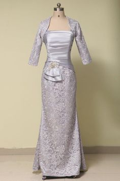 a dress on a mannequin with a jacket over the top and a bow at the waist