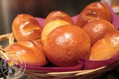 bread rolls in a wicker basket on top of a stove burner with purple cloth