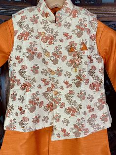 Boys Kurta Pajama Set with Jacket in Floral Weave Work. Item : Boys Kurta Pajama Ready to Wear : Yes Kurta Color : Orange with Light Gold Jacket with floral Pattern Pajama Color : Light Gold Fabric : Silk Pocket : Yes Lining : Yes Disclaimer- There can be little variation in the color due to screen resolution setting, phone display setting or anything else. Kindly do not hold us responsible. Eid Festive Choli With Printed Motifs, Festive Eid Choli With Printed Motifs, Festive Floral Print Sets For Transitional Seasons, Transitional Festive Sets With Floral Print, Cotton Nehru Jacket For Navratri Designer Wear, Designer Nehru Jacket With Printed Motifs For Festivals, Traditional Nehru Jacket With Floral Print For Designer Wear, Cotton Bandhgala With Printed Motifs For Festive Occasions, Bollywood Style Festive Sherwani With Printed Motifs