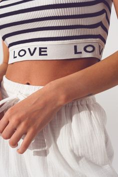 Introducing our stylish Striped Crop Top with Love Text in White, a trendy and comfortable addition to your wardrobe. Designed with attention to detail, this crop top offers a perfect blend of style and comfort. With its cropped length, this top is perfect for creating a fashionable and contemporary look. The stripe design adds a touch of sophistication, while the contrast collar adds a stylish element to the overall design. The sleeveless style allows for ease of movement and breathability.  Th Trendy Cropped Hem Summer Bottoms, White Cropped Hem Crop Top For Summer, Summer Fitted Crop Top For Loungewear, Fitted Summer Crop Top For Loungewear, Casual Cropped Crop Top For Day Out, Cotton Cropped Top For Loungewear, White Cotton Crop Top With Cropped Hem, White Summer Crop Top For Loungewear, Casual Crop Top With Elastic Waistband