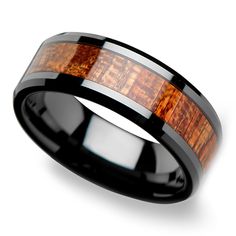 a black ceramic ring with wood inlays on the inside and an orange wooden inlay