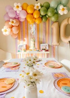 the table is set with flowers and balloons