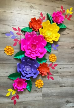 paper flowers are arranged on a wooden floor