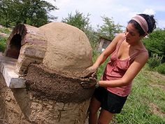 a woman is making a sand sculpture out of dirt and cement blocks in the grass