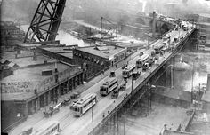 an old black and white photo of buses on a bridge