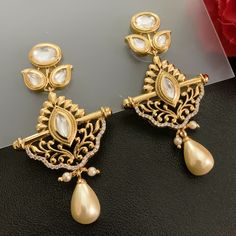 Fashionable and stylish, this pair of 18K Gold Plated Kundan Earrings will make you shine and stand out. This color works well with a variety of outfits. You can wear them with traditional outfits, western outfits, indo-western outfits, or casual gatherings. Best for gifting or for personal use, wear it to any occasion and be the spotlight. Eye-catching and unique jewelry that will set you apart. Gift this piece to a loved one, and see their face light up with joy. Length ~ 5 cm Elegant Chandbalis For Eid, Elegant Jhumkas For Diwali Festival, Elegant Jhumkas For Diwali Festivities, Elegant Kundan Danglers For Celebration, Elegant Pearl Meenakari Earrings For Diwali, Elegant Plug Earrings For Festive Celebration, Elegant Festive Celebration Plug Earrings, Elegant Eid Chandbalis With Intricate Design, Elegant Eid Danglers