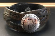 "Each Leather Cuff Bracelet is hand stamped and dyed.  Pictured is the Medium Brown Finish.  Each Bracelet is adjustable with two snaps for the closure.  The Braided \"Fearless\"\" Bracelet fits wrist sizes 7-1/2\"-8-1/2\".  If you see another design you would like stamped with the Fearless Tag, or another finished dye color, a custom order can be made.   Total Length: 9-1/2\" Thickness:  1/16\" Width:  1\"" Adjustable Hand Stamped Vintage Cuff Bracelet, Vintage Adjustable Hand Stamped Cuff Bracelet, Vintage Adjustable Cuff Bracelet Hand Stamped, Hand Stamped Adjustable Vintage Cuff Bracelet, Adjustable Hand Stamped Cuff Bracelet For Everyday, Adjustable Stamped Leather Cuff Bracelet, Adjustable Stamped Cuff Bracelet For Everyday, Adjustable Stamped Everyday Cuff Bracelet, Adjustable Stamped Bracelets For Festivals