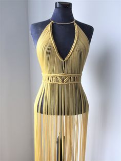 a mannequin wearing a yellow dress with fringes