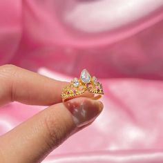 a woman's hand holding a yellow and white diamond ring on top of her finger