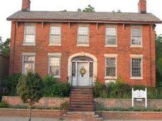 an old brick house with steps leading up to the front door