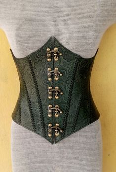 It is Embossed Floral Design handmade leather underbust corset with hand-sewn leather detailing. It's adjustable back side with buckles. We used about 2 to 2.2 mm thick handmade leather. It is hand dyed handmade leather. Corset is hand made from sturdy top-grain leather.  Size is available from 30 to 46 inch, please check our size chart. DETAILS: ► 100% Handmade ► 100% Genuine leather ► Made on your measurements ► Unique design ► LARP standard ► Worldwide delivery Usually it takes about 1 weeks Steampunk Corset Belt For Fantasy Events, Green Corset Top, Fantasy Style Corset Belt For Larp, Fitted Fantasy Corset Belt For Larp, Medieval Style Fitted Leather Corset, Leather Steampunk Corset Belt For Festivals, Elegant Green Overbust Corset, Fitted Leather Corset For Cosplay, Green Leather Armor