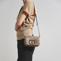 Beige leather crossbody bag from Roger Vivier. The Vic Choc crossbody bag is made of leather with an elegant drape and iconic branded metal rounded buckle. It is closed with flap and magnetic button, and comes with a removable shoulder strap and zipped pocket on the back. Measurements: L24 x H12.5 x W6 cmMade in Italy Beige Bag, Elegant Drapes, Roger Vivier, Leather Crossbody Bag, Leather Crossbody, Crossbody Bag, Shoulder Strap, In Italy, Buckle