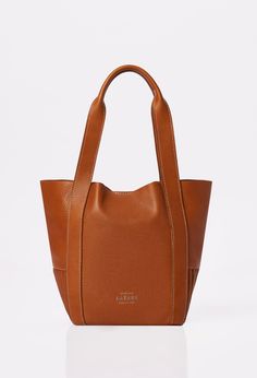 Front of a Tan Leather Mini Bucket Bag Ushuaia with Lazaro logo and contrast stitching highlights. Satchel Bags With Leather Handles For Everyday, Timeless Pouch Shoulder Bag With Dust Bag, Timeless Satchel With Leather Handles For Daily Use, Everyday Top Handle Leather Bag, Functional Everyday Satchel With Leather Lining, Everyday Functional Satchel With Leather Lining, Daily Top Handle Bag With Leather Handles, Timeless Travel Shoulder Bag With Dust Bag, Timeless Cognac Bag With Leather Handles