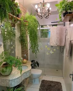 a bathroom with a toilet, shower and plants in it