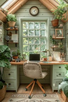 a desk with a laptop on it in front of a window filled with potted plants