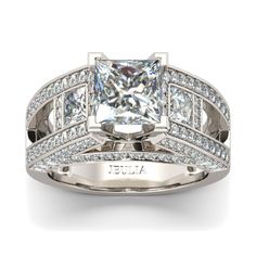 With style and shimmer, this engagement ring creates a vintage vibe you'll love to wear. It showcases a shimmering princess-cut stone at the center, while glistening rows of smaller stones line the ring's open shank. Buffed to a brilliant luster, this engagement ring is as timeless as your romance.Carat Weight: 2.85 ctStone Size: 7*7 mmStone Type: Jeulia® StoneNumber of Stones: 1 Stone Color: Diamond WhiteStone Shape: PrincessCarat Weight: 2.512 ctStone Size: 4*4,1 mmStone Type: Jeulia® StoneNumber of Stones: 140 Stone Color: Diamond WhiteStone Shape: Princess, RoundWeight: 7.83 gWidth: 8.6 mmHeight: 9.2 mmThickness: 4.3 mmMaterial: 925 SilverPlating Color: Silver Vintage Art Deco Rings, Amethyst Ring Engagement, Wedding Rings Halo, Fancy Diamonds, Split Shank, Emerald Engagement Ring, Art Deco Ring, White Sapphire, Womens Engagement Rings