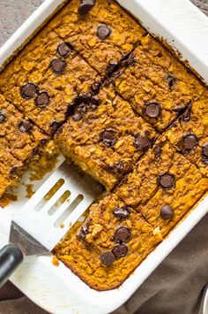 a casserole dish with chocolate chips on top and a spatula in it