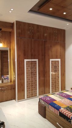 a bed room with a neatly made bed and wooden closets on the wall behind it