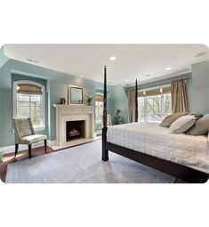 a bedroom with blue walls and white bedding, fireplace in the corner and chair at the foot of the bed