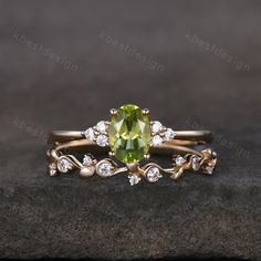 a close up view of a ring with a green stone and white diamonds on it