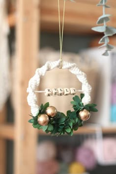 an ornament hanging from a rope with two balls and leaves in the center