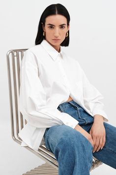 Relaxed and feminine, our oversized Raphaela Shirt is a true dream. Fashioned from crisp European poplin cotton, she's tailored with a sharp collar and a button front, which evens out her floaty shape and dolman sleeves. | Emily, in white, is 5'9.5" (177 cm) tall, wearing size XS. Approximately 29.5" (75 cm), measured from the shoulder to the bottom hem. Sleeve length approximately 22.5" (57.5 cm).100% European Poplin Cotton. Machine wash on delicate cycle or hand wash in cold water. Tumble dry Oversize Shirt, Boyfriend Shirt, The A Team, Summer Clothing, Black Xs, Oversized Shirt, Dolman Sleeve, Shirt Outfit, A Button