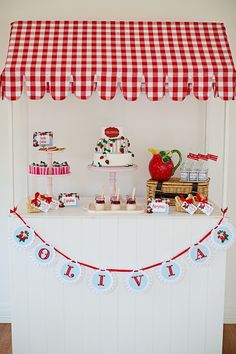 a red and white checkered awning over a dessert table