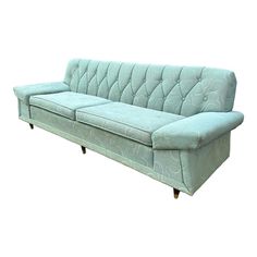 a light blue couch sitting on top of a wooden table next to a white wall