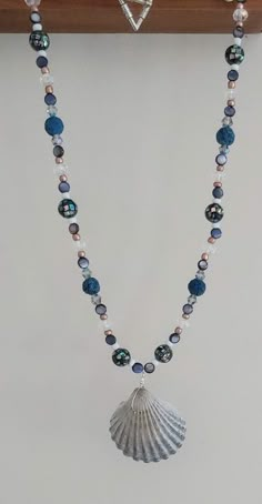 This necklace is made with navy lava beads, natural shell beads, gold seed beads, clear rondelles, multi-color bicone crystal beads, speckled beads, and a scallop shell in the middle. Toggle clasp. Measures 21 inches long end to end. Siren Core, Beaded Shell, Seashell Jewelry, Ocean Jewelry, Scallop Shell, Lava Beads, Scallop Shells, Adam Sandler, Lava Bead