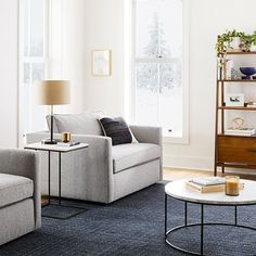 a living room with two couches and a coffee table in front of a window