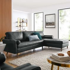 a living room with black leather furniture and large windows in the backround area