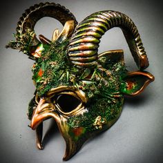 This Forest Devil Mask with Twist Back Ram Horns is made from plastic, and hand-crafted with different elements then painted for a beautiful unique mythological forest look. The mask is about 12" tall and 12" wide. The masquerade mask will make a great costume accessory. This masquerade can also be a creative home wall decor after the party. Product Feature Made from Plastic with Plastic Plastered and Hand Crafted and hand painted. Great for a Masquerade Ball, Venetian Costume, or Halloween Costume Features Mythological Beasts May Also Be Used as a Display Piece Hand Painted and textured with plaster for a unique texture finish Face mask size: 7" x 6.5" x 4" Full mask size: 12" x 12" x 6" Mask Color: Gold Green Handmade Masquerade Mask For Halloween Cosplay, Handmade Fantasy Masks And Prosthetics For Carnival, Handmade Fantasy Masquerade Mask For Costume Party, Handmade Fantasy Masks And Prosthetics For Costume Party, Fantasy Masquerade Mask For Halloween, Green Halloween Masquerade Mask And Prosthetics, Green Halloween Masquerade Mask, Themed Halloween Masquerade Mask, Fantasy Masks And Prosthetics For Carnival And Halloween