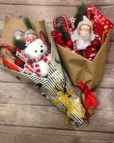 two christmas decorations in a paper bag on a wooden table next to a teddy bear