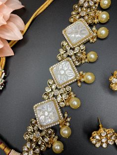 This elegant and gorgeous choker with matching earrings and is sure to be a hit for any event! The beautiful ivory color with gold pearls can match any outfit and the color is a gorgeous shade with a beautiful finish. Gold Sets With Pearl Embroidery For Reception, Elegant Kundan Choker Necklace, Elegant Kundan Choker Necklace For Formal Occasions, Elegant Formal Kundan Choker Necklace, Elegant Kundan Choker For Formal Occasions, Elegant Formal Kundan Choker, Elegant Gold Sets For Reception, Elegant Kundan Bridal Choker Necklace, Elegant Festive Kundan Choker