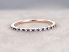 a white gold band with blue and white diamonds on it, sitting on top of a table