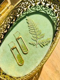 Handmade in Austin, TX, these REAL pressed fern earrings are beautifully preserved using resin.  Ear wire: 18k gold plated 304 Surgical Stainless Steel Bezel: gold plated Brass Lead and Nickel free - Hypoallergenic  Due to the handmade nature of this product, slight variations may occur.  *JEWELRY CARE:* -Remove jewelry prior to bathing, swimming, or exercising -Keep away from chemicals or perfumes -May be wiped/polished with a soft microfiber cloth Find and tag us on Instagram at @indigoandlily Botanical Leaf-shaped Jewelry Gift, Botanical Leaf-shaped Jewelry For Gifts, Nature-inspired Green Jewelry With Pressed Flowers, Green Brass Earrings Nature-inspired, Fern Earrings, Pressed Fern, Plant Earrings, Leaf Plant, Green Leaf