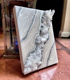 a white and grey marble block sitting on top of a floor next to a mirror