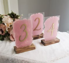 three pink and gold numbers on wooden bases