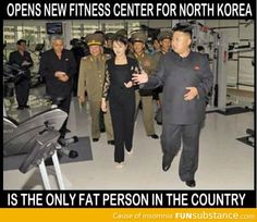 a group of people standing around each other in a room with machines and treadmills