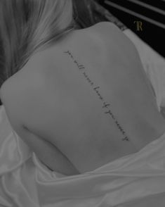 the back of a woman's shoulder with an inscription on it