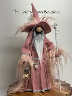 a pink and white wizard doll sitting on top of a wooden table next to a key