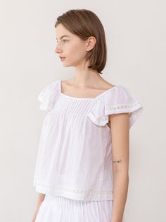 This is a feminine and unique top by JMARK New York that is made out of high quality and sturdy fabric. With trendy design detail and refined romantic mood, you can style it for your daily casual outfit.- Elastic band on the shoulder- Pin tuck detail on the front- Set up with matching skirt Summer Feminine Blouse With Flutter Sleeves, Feminine Summer Blouse With Flutter Sleeves, Feminine Flutter Sleeve Summer Blouse, Casual White Off-shoulder Peasant Top, Spring Cotton Off-shoulder Top With Ruffles, Feminine Cotton Peasant Top For Brunch, Summer Feminine Blouse With Ruffle Sleeves, Cotton Off-shoulder Top With Ruffles, Feminine Summer Blouse With Ruffle Sleeves