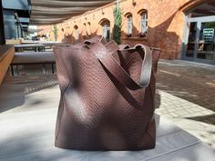 Color and texture are the most important things in this bag. The color is dark brown, the color of dark chocolate. It is a natural genuine leather. The leather is embossed with asnake. The bag is a medium-sized shopper. The bag has an outer pocket on the back - zippered. The bag easily fits A4, but will not overwhelm the figure. Details: -natural leather with snake embossing - color - dark brown -closure of the bag with a zipper - an outer zippered pocket on the back -Inside lining, zip pocket a Tan Textured Leather Shoulder Bag For Daily Use, Chic Brown Shoulder Bag As Gift, Large Elegant Brown Shoulder Bag, Chic Brown Shoulder Bag For Gift, Large Brown Bags With Leather Handles, Tan Textured Leather Shoulder Bag, Chic Large Brown Shoulder Bag, Tan Tote Shoulder Bag Gift, Tan Tote Shoulder Bag For Gift